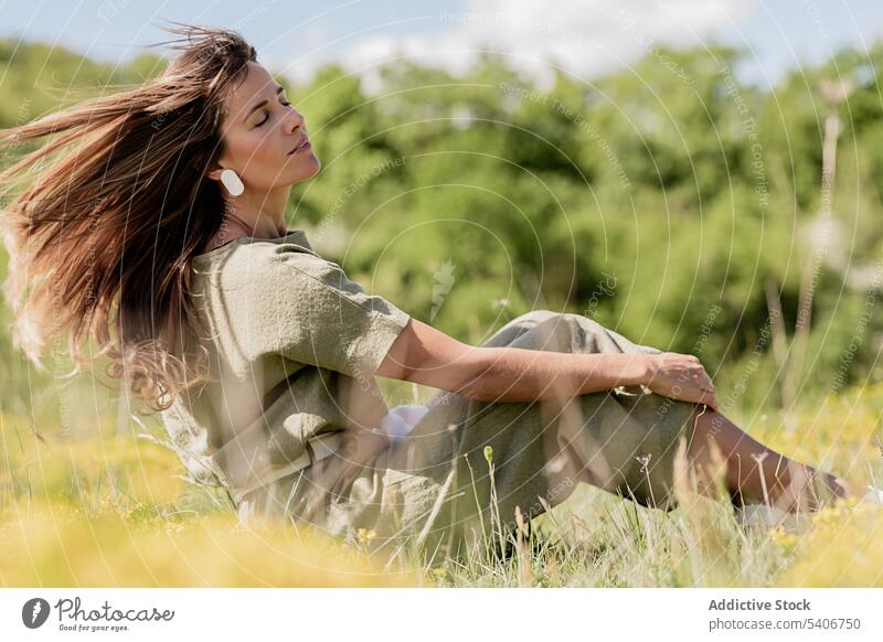 Verträumte Frau mit wallendem Haar auf einer Wiese ruhend verträumt sich[Akk] entspannen Feld Gras nachdenklich Natur genießen Landschaft jung grasbewachsen