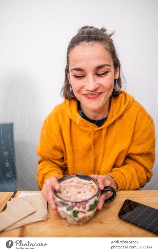 Fröhliche Frau mit einer Tasse Kaffee trinken gemütlich Café Lächeln Smartphone positiv sich[Akk] entspannen jung lässig Glück Getränk Gerät Tisch Mobile