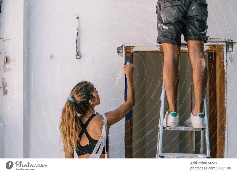 Ehepaar malt tagsüber die Wand zu Hause Paar Farbe dreckig Zusammensein heimwärts renovieren Reparatur Arbeit verbessern Appartement Erneuerung Partnerschaft