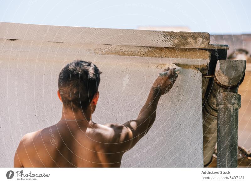Anonymer Mann streicht sein Haus während der Renovierung Farbe weiß Wand heimwärts renovieren Arbeit wohnbedingt verbessern Anstreicher Prozess Erneuerung