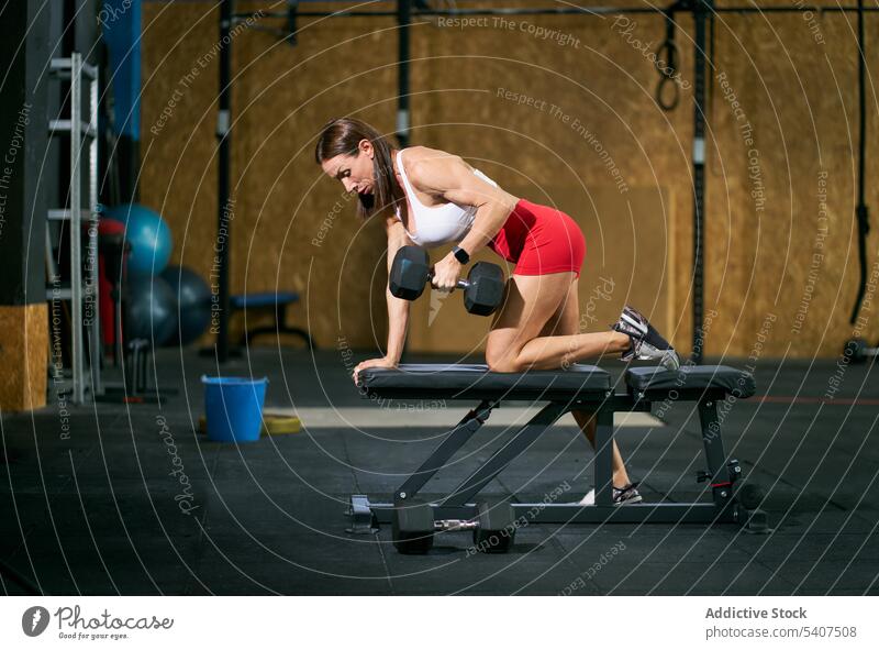 Positiver Sportler beim Training auf einer Bank mit Hantel Sportlerin Übung Gewichtheben Kurzhantel schwer Fitness Frau reif muskulös Stärke Ausdauer üben Gerät