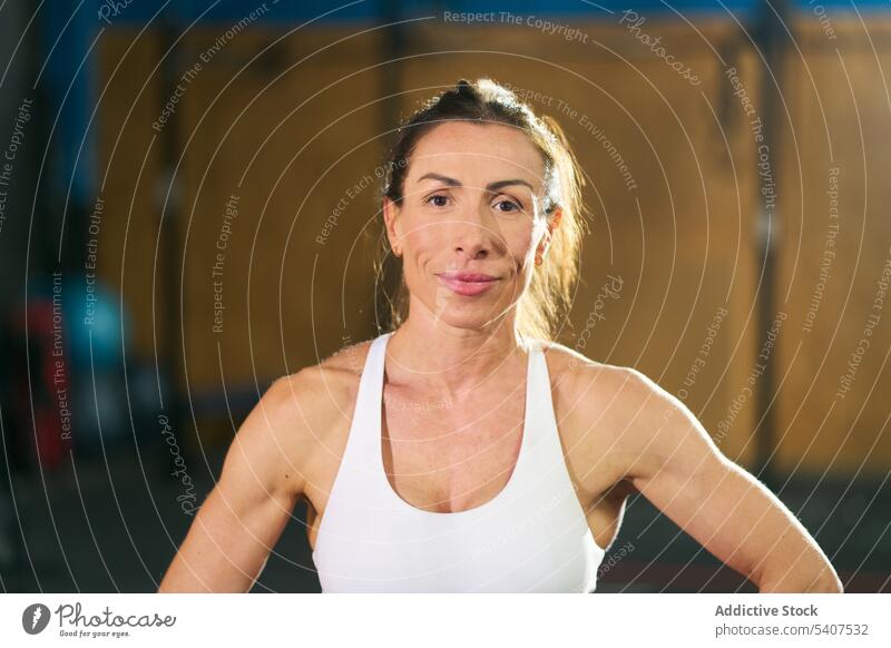 Lächelnde muskulöse Sportlerin im Fitnessstudio stehend Porträt selbstbewusst Körper Training Vorschein stark Frau Erwachsener Top Vitalität Motivation Wellness