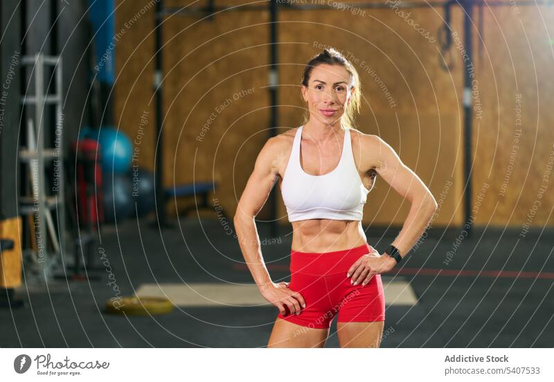 Lächelnde muskulöse Sportlerin im Fitnessstudio stehend selbstbewusst Körper Training Vorschein stark Frau Erwachsener Top Vitalität Motivation Wellness passen