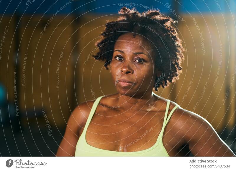 Schwarze reife Sportlerin mit Afrofrisur Porträt selbstbewusst Training stark muskulös Fitness Fitnessstudio Gesunder Lebensstil Wellness emotionslos Frau
