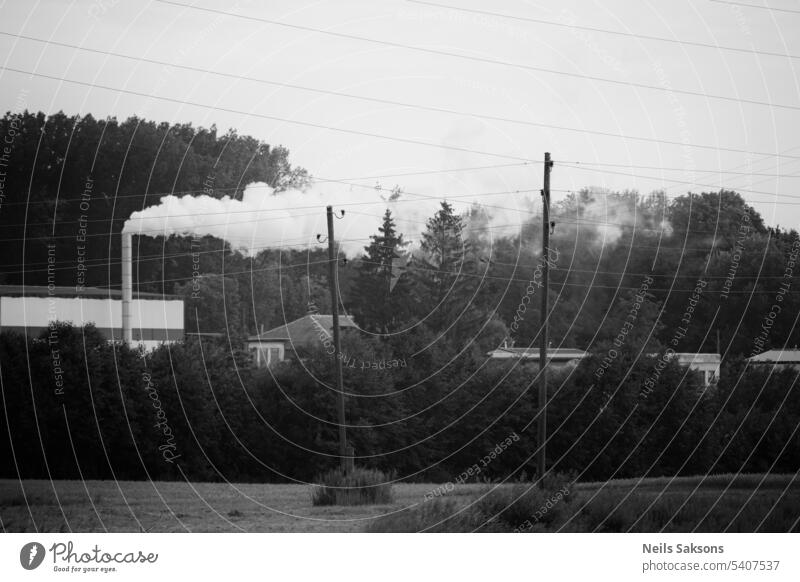 Schwarz-Weiß-Industrielandschaft. Strommasten und Drähte in der Luft, Rauch kommt aus dem Schornstein abstrakt Architektur Atmosphäre Hintergrund