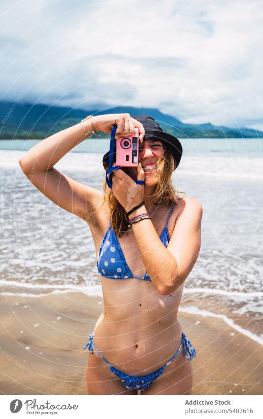 Weiblicher Tourist steht am Strand und macht ein Foto Frau fotografieren Filmmaterial retro Fotoapparat nass MEER Sand Sommer jung uvita Puntarenas Costa Rica