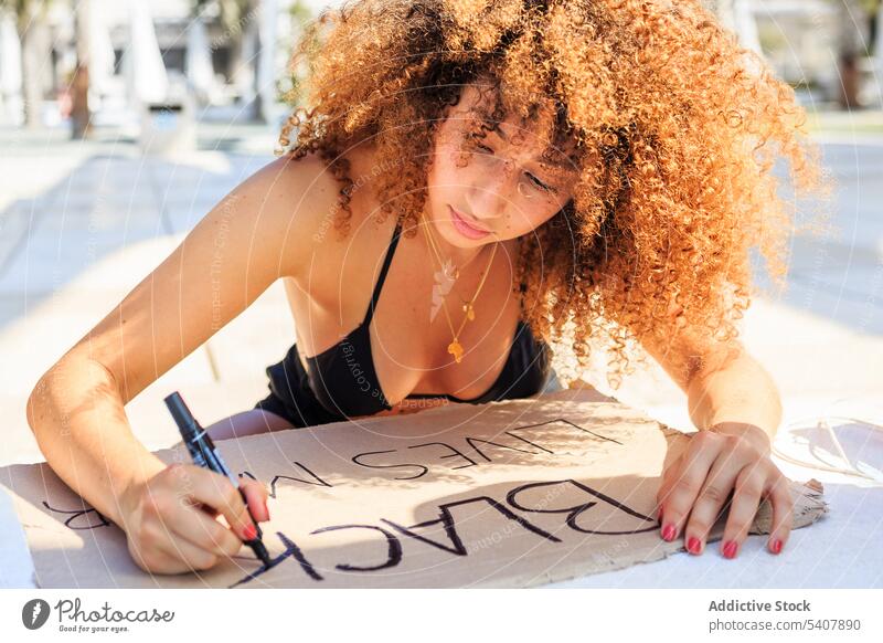 Afroamerikanische Frau entwirft "Black lives matter"-Poster Schwarze Leben Materie protestieren manifestieren Großstadt Markierstift schreibend Plakat