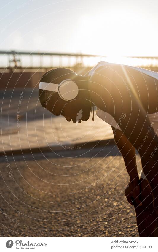 Erschöpfter schwarzer Läufer, der sich nach dem Lauftraining aufs Knie stützt Sportler Pause Training Fitness ruhen Müdigkeit erschöpft Athlet Mann Wohlbefinden