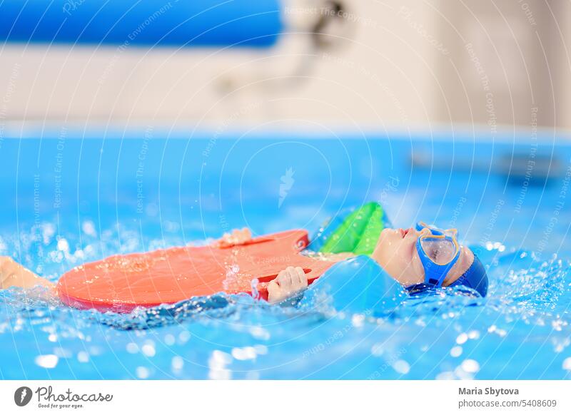 Kleiner Junge mit Brille und aufblasbaren Armbändern im Schwimmbad. schwimmen lernen Kind Pool Armbinden Schwimmsport Sport Abschnitt Bildung Lektion