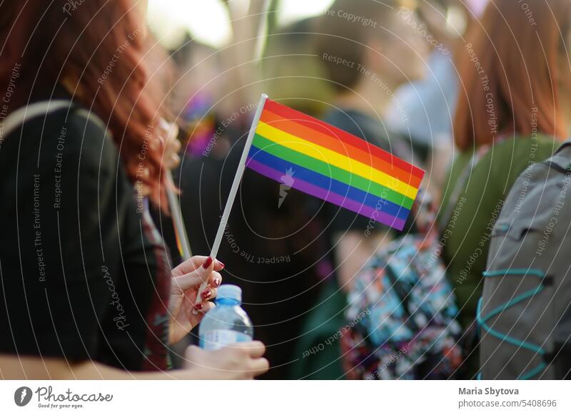 Aktivistin mit Regenbogenfahne und Banner auf dem Marsch auf der Stadtstraße während der Lgbt Pride Parade. Kämpfen für die Gleichstellung sexueller Minderheiten.
