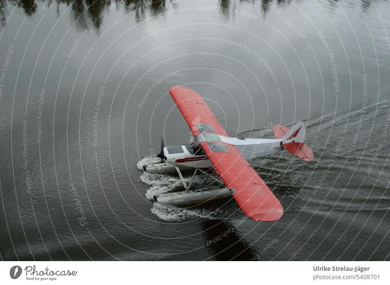Alaska | Buschpilot | ein Wasserflugzeug landet Flugzeug Pilot Landung Wasserlandung Tragflächen rot rote Tragflächen Spiegelung Baumspiegelung Abenteuer