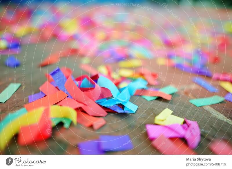 Buntes Papier-Klebeband liegt auf dem Boden nach einer Hochzeit, einem Geburtstag, Karneval, einer LGBT-Parade oder einem Fest im Freien. Nach der Party.