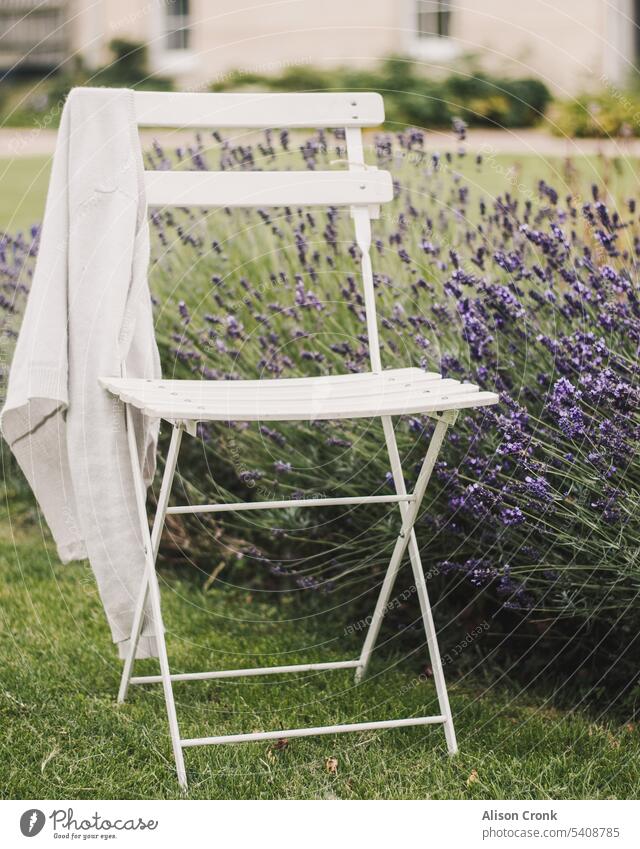 weißer gartenstuhl mit einer strickjacke von lavender Lavendel Provence weißer Stuhl Bistrostuhl Gartenstuhl außerhalb Außenbestuhlung draußen sitzend