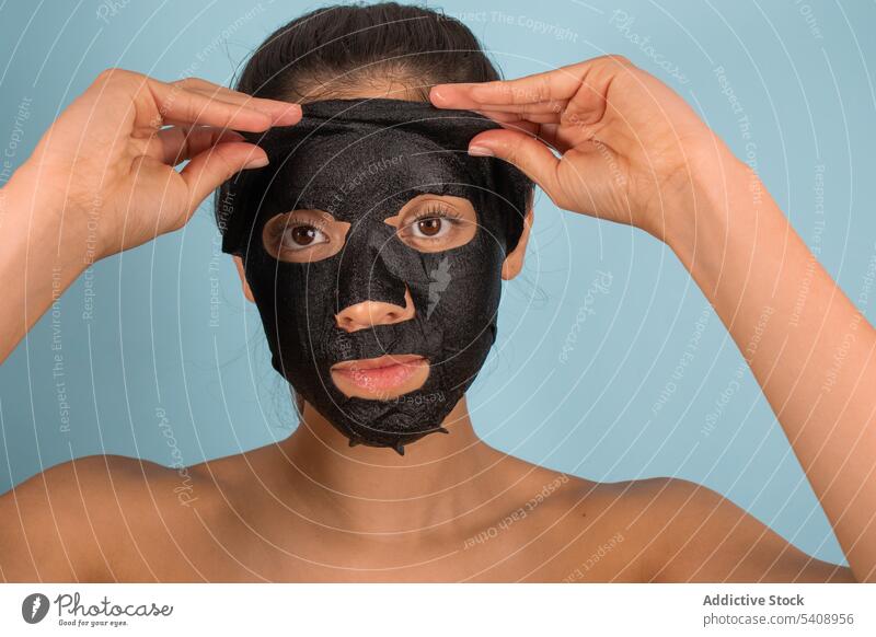 Frau entfernt Maske auf Gesicht in Studio Hautpflege Mundschutz Maske aus Bambuskohle Kosmetik Schönheitsprogramm Gesichtsbehandlung Porträt Kosmetologie