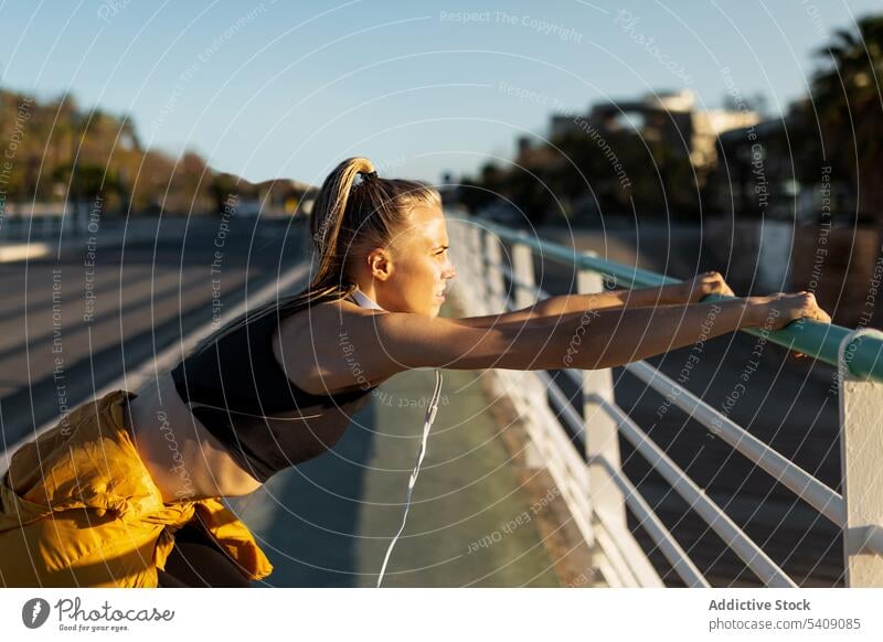 Junge Frau dehnt sich nach dem Training im Freien bei Sonnenuntergang jung Jogger Athlet Läufer rennen Sport Gesundheit passen Fitness sportlich Übung Lifestyle