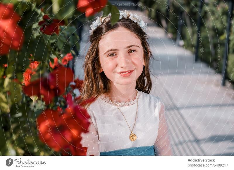 Glückliches charmantes Mädchen im Blumenkranz Kleid Park Porträt Lächeln geblümt Freude froh Stil Natur positiv Kind Flora Lifestyle grün Blüte Optimist Dame