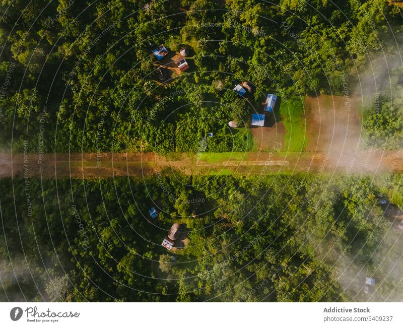Drohnenansicht eines grünen tropischen Waldes Dorf Hügel Landschaft Regenwald Haus Straße Baum Natur malerisch Cottage friedlich Berghang Wohnsiedlung ländlich