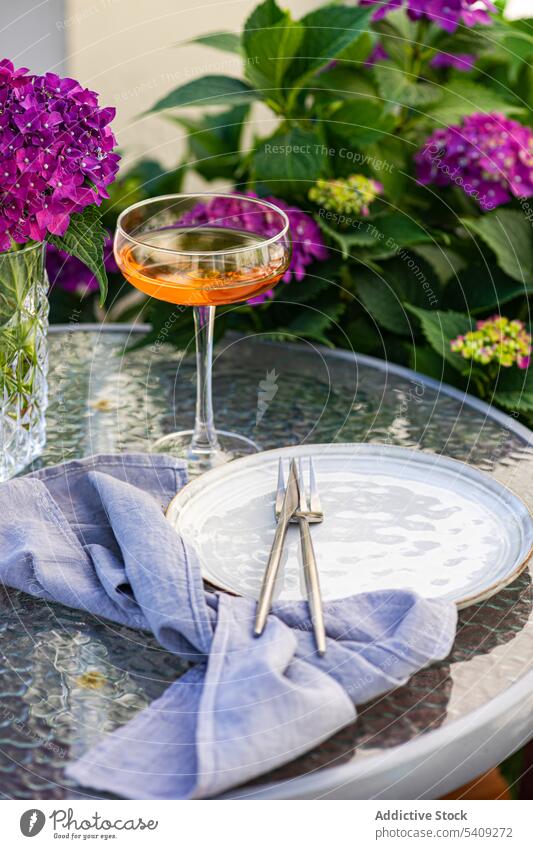 Vase mit Blumen auf dem Tisch neben dem Teller Blumenstrauß Hortensie Garten Glas dienen trinken kreativ Dekor Getränk Keramik purpur Design frisch Pflanze