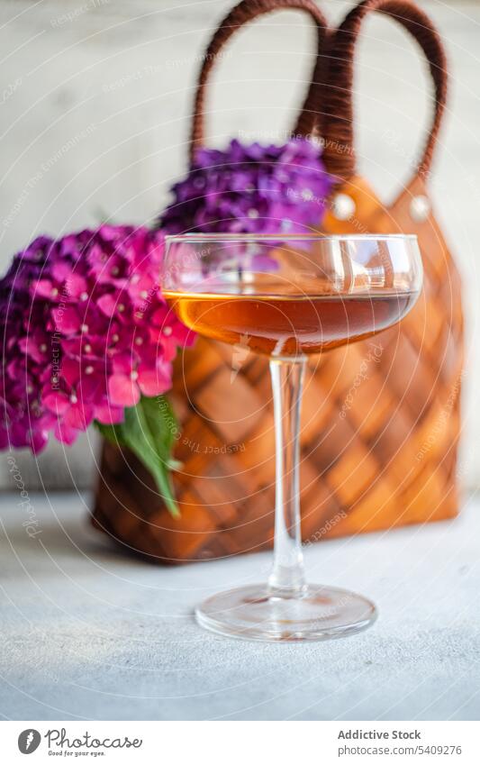 Blumen neben Glas mit Getränk Blütezeit Blumenstrauß Dekoration & Verzierung trinken frisch natürlich geblümt Alkohol purpur Tisch Pflanze Haufen Korb Flora