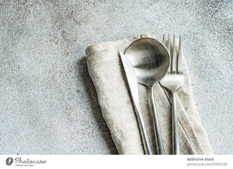 Besteck auf Handtuchserviette gelegt Löffel trocknen Silberwaren Serviette Küche Kulisse Utensil Tisch Oberfläche rau grau Textur Gewebe Geschirr Küchengeräte