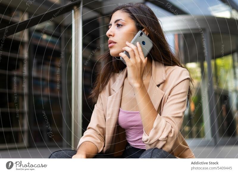 Junge Frau spricht mit Smartphone Geschäftsfrau nachdenklich besinnlich Gespräch reden Telefonanruf formal urban Kommunizieren Gebäude sprechen ethnisch