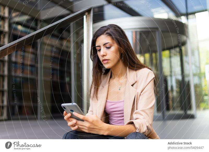 Geschäftsfrau benutzt Smartphone in der Nähe eines Gebäudes Konzentration Fokus benutzend Textnachricht online Nachricht Texten Manager Großstadt Frau Internet