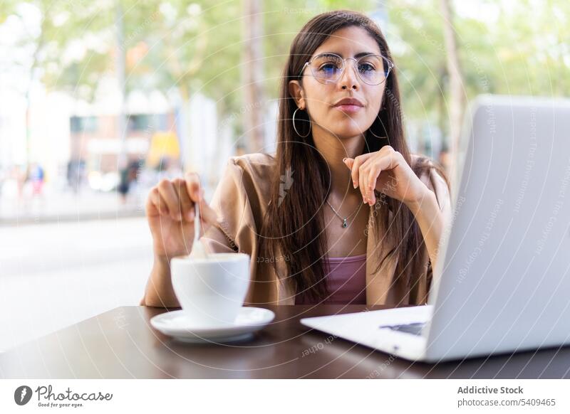 Konzentrierte Frau arbeitet am Laptop in einem Café Geschäftsfrau Unternehmer Konzentration nachdenklich Fokus Arbeit benutzend Tippen Netbook Telearbeit
