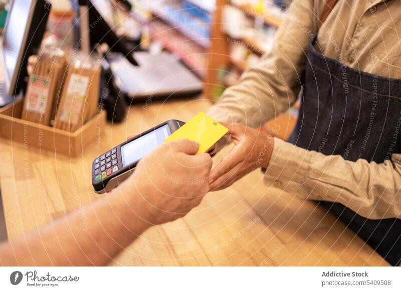 Crop-Mann beim Bezahlen mit Kreditkarte in der Drogerie Zahlung Klient Kunde bezahlen Kauf Transaktion POS-Maschine Terminal Laden Finanzen Gerät Postkarte