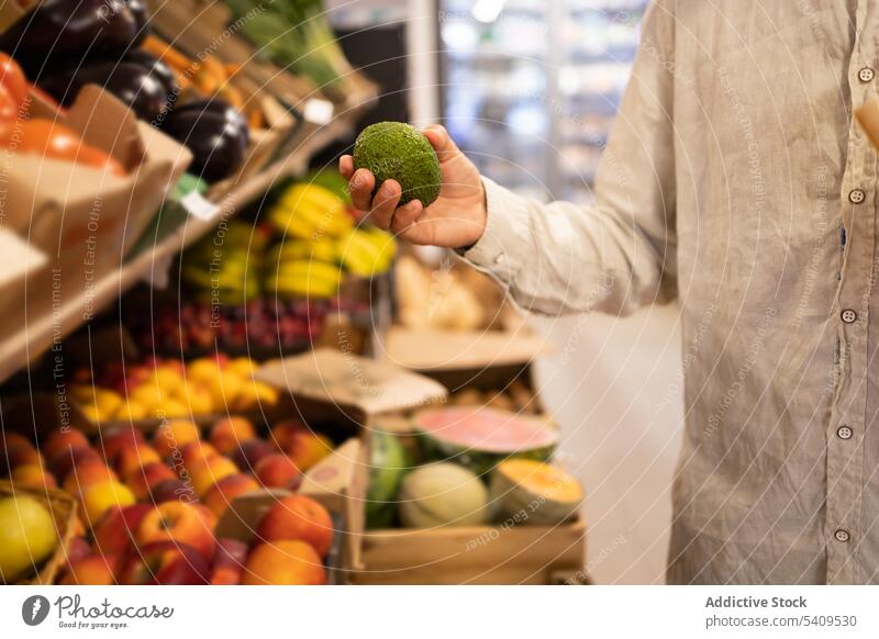 Mann wählt Obst im Obstladen aus Lebensmittelgeschäft Laden Frucht wählen Person Supermarkt Kauf Produkt Käufer Kunde verschiedene Regal Wahl Werkstatt reif