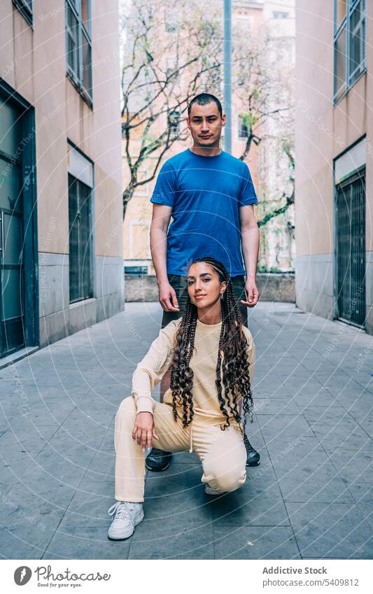 Stilvolles Paar posiert auf der Straße Mann Frau Großstadt Stadt Gebäude Zusammensein Outfit Partnerschaft Wand Geflecht trendy sitzen hispanisch Straßenbelag