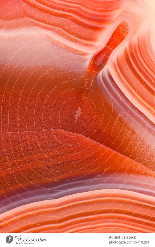 Erstaunlicher Achatkristall-Querschnitt mit hypnotisierenden Schichten aus orangefarbenen und violetten Wellenlinien Kristalle Felsen Textur Mineral abstrakt