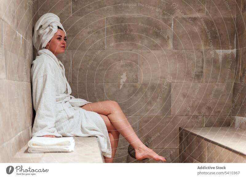 Junge Frau in Badekleidung mit Kopftuch im Sitzen Bademantel Terrasse Routine Spa Hygiene Handtuch Resort Urlaub ruhen sich[Akk] entspannen Hammam jung Sommer