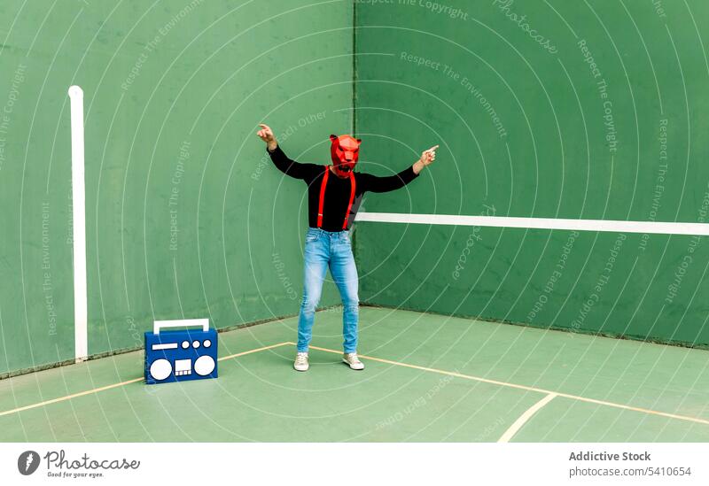 Mann mit Tiermaske tanzt neben Boombox Mundschutz Tanzen Sportpark unterhalten ausführen Musik cool sorgenfrei männlich Energie sich[Akk] bewegen Aktivität Typ
