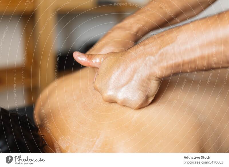 Unbekannter Masseur trägt tagsüber Öl auf den Rücken eines anonymen Kunden auf Klient Massage bewerben drücken Tisch Spezialist Salon professionell Leckerbissen