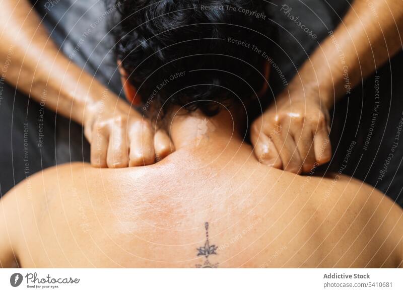 Unbekannter Masseur bei einer tiefen Gewebemassage an den Schultern eines anonymen Kunden Mann Therapeut Frau Klient Massage kneten Finger männlich Spezialist