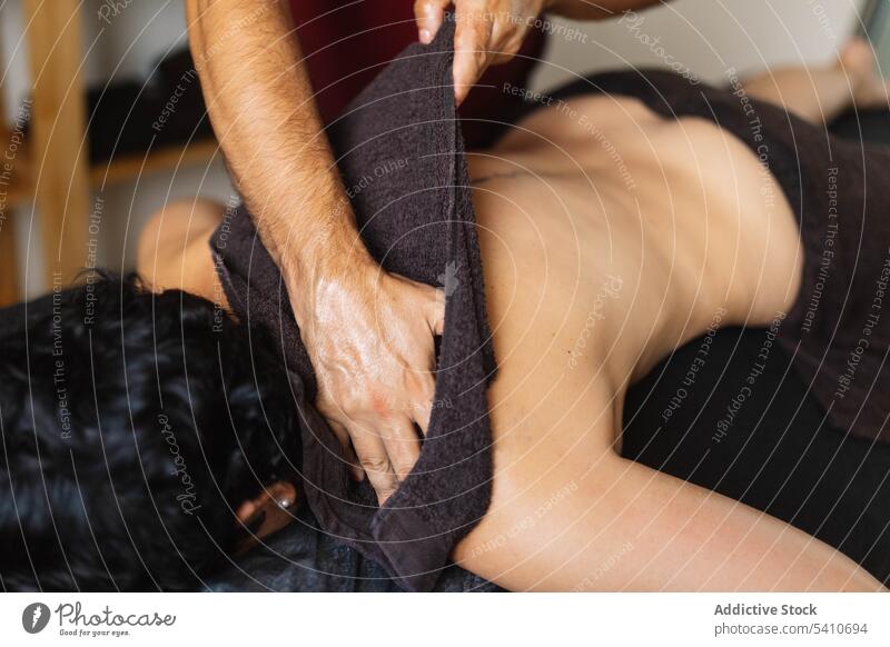 Unbekannter Masseur massiert die Schulter einer anonymen Frau auf dem Tisch Therapeut Mann Klient Leckerbissen Lügen Gewebe männlich Hand Therapie Stoff