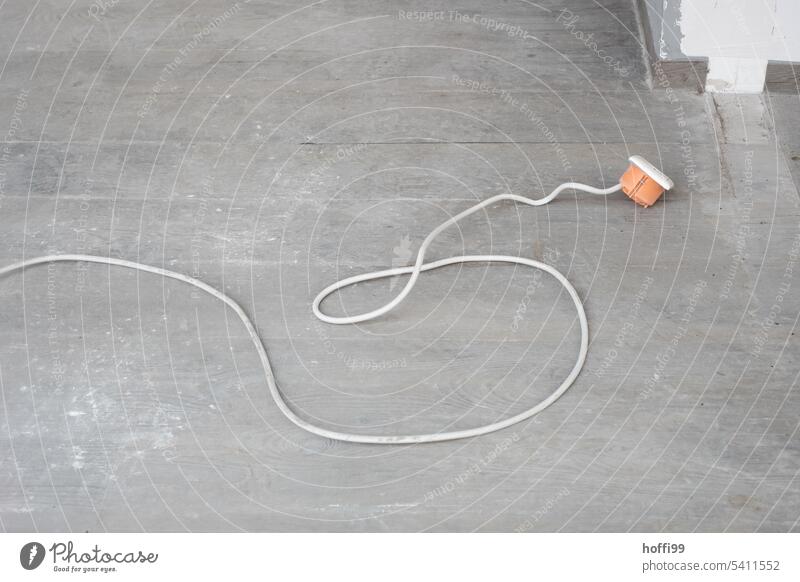 Kabel mit herausgerissener Unterputzdose auf Betonboden Elektroinstallation Abrissgebäude unterputzdose Baustelle Elektrizität Verfall Demontage Vergänglichkeit