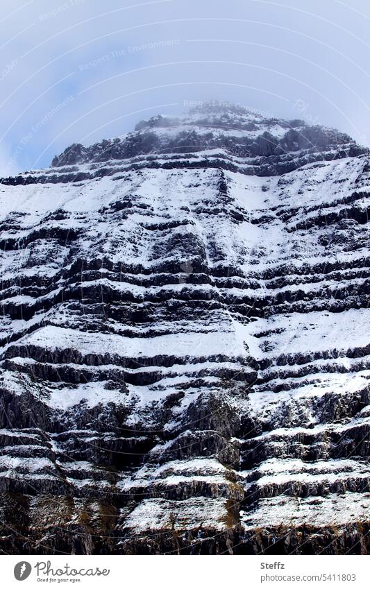 schneebedeckter steiler Felshügel auf einer Färöer Insel Färöerinseln Färöer Inseln Färöer-Inseln Schafsinseln Felseninsel Felsufer Steilwand Steilufer