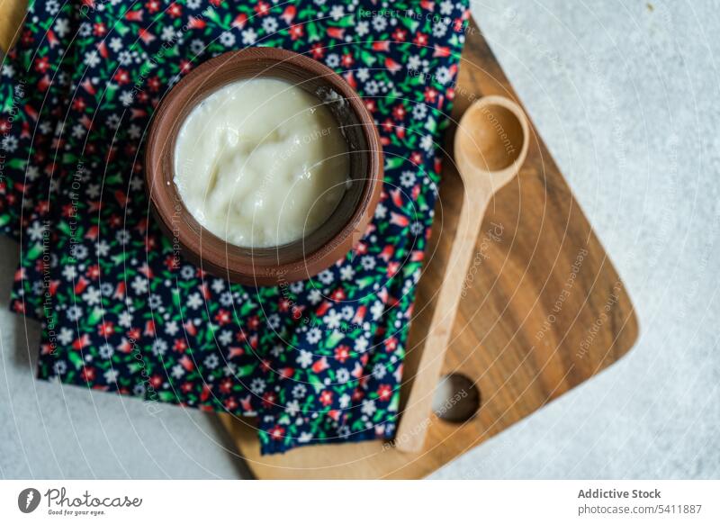 Traditionelle Portion georgischer saurer Joghurt, bekannt als Matsoni, im Tontopf sauer traditionell Dessert Kultur matsoni Topf Löffel hölzern rustikal
