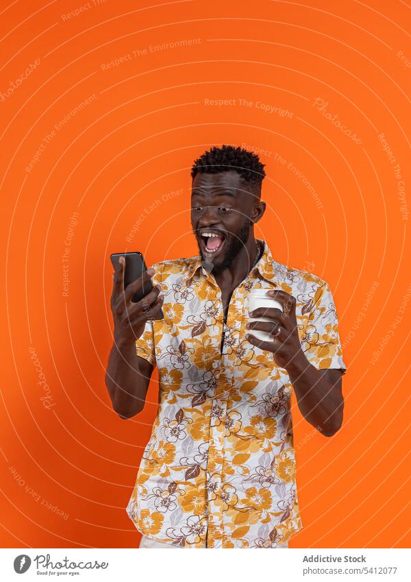 Schwarzer Mann mit Smartphone und Tasse Kaffee Selfie benutzend Afro-Look heiter Moment Gedächtnis Lächeln fotografieren Glück Funktelefon Telefon Mobile Gerät