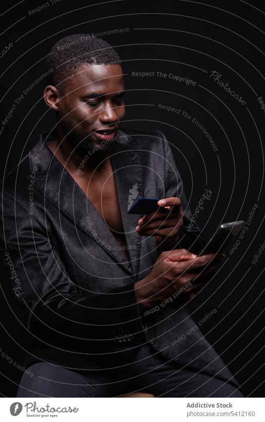 Schwarzer Mann bewegt sich auf Smartphone sich[Akk] bewegen Kreditkarte Telefonanruf reden benutzend Kommunizieren Gespräch Apparatur Gerät männlich Mobile