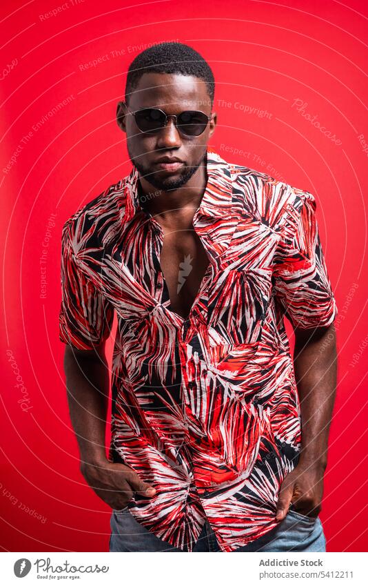 Stilvoller schwarzer Mann mit Sonnenbrille und Tropenhemd trendy Mode selbstbewusst Outfit Vorschein Porträt Model Hemd männlich Afroamerikaner ernst