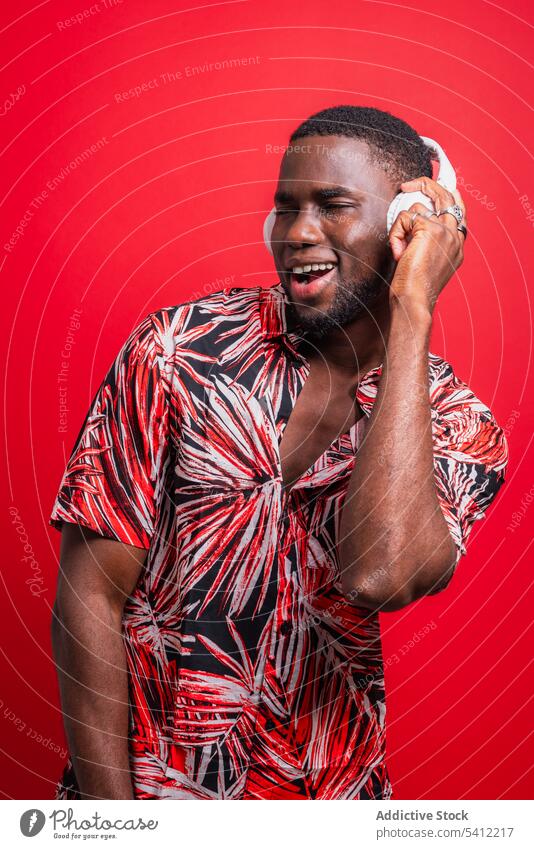 Glücklicher afroamerikanischer Mann, der Musik hört zuhören genießen singen Gesang Drahtlos Kopfhörer Wiedergabeliste benutzend echte drahtlose positiv Optimist