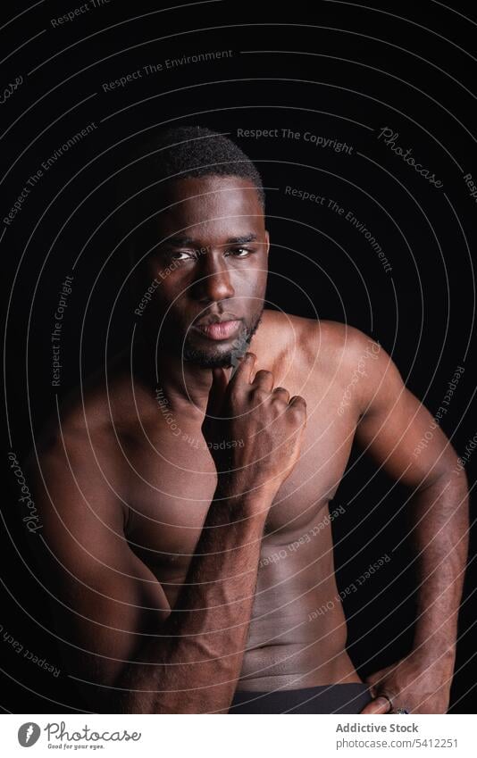 Ernster schwarzer Mann mit nacktem Oberkörper schaut in die Kamera Sportler Athlet muskulös ohne Hemd Porträt nackter Torso Macho selbstbewusst maskulin stark