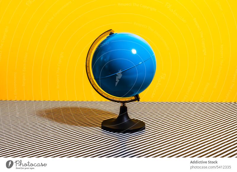 Globus auf gestreifter Oberfläche unfertig Schreibwarenhandlung hell farbenfroh Erde Geografie blau Welt Kugel Kontinent Farbe gelb Tisch einfach sehr wenige