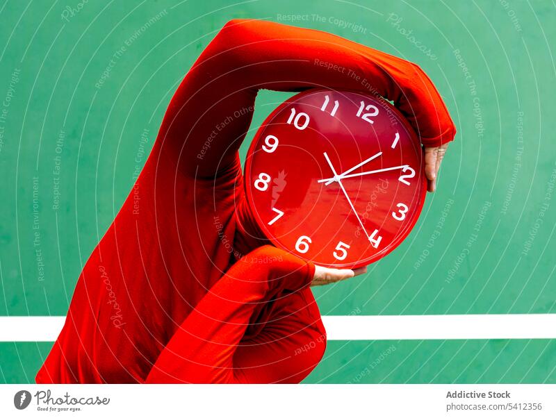 Anonyme Person, die ihr Gesicht mit einer roten Uhr bedeckt Zeit Tierhaut Deckblatt Stunde sich[Akk] beeilen punktuell Konzept Mysterium Minute kreisen hell