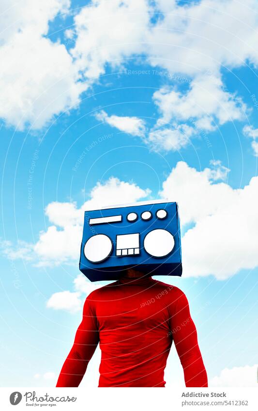 Anonymer Mann, der sein Gesicht mit einer Boombox unter dem Himmel bedeckt Deckblatt zuhören Musik Freizeit sorgenfrei Hobby retro altehrwürdig Blauer Himmel