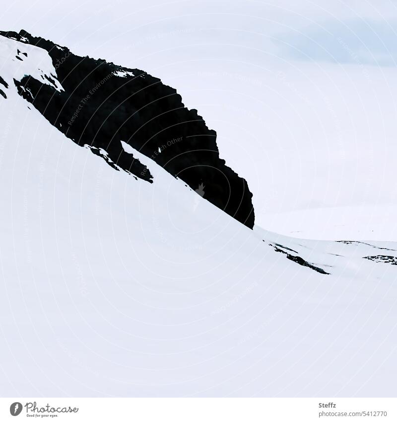 Schnee und Felsen auf Island bilden manchmal bizarre Formen Ostisland Schneedecke Islandwetter schneebedeckt isländisch Stille verschneit felsig leer Ost-Island