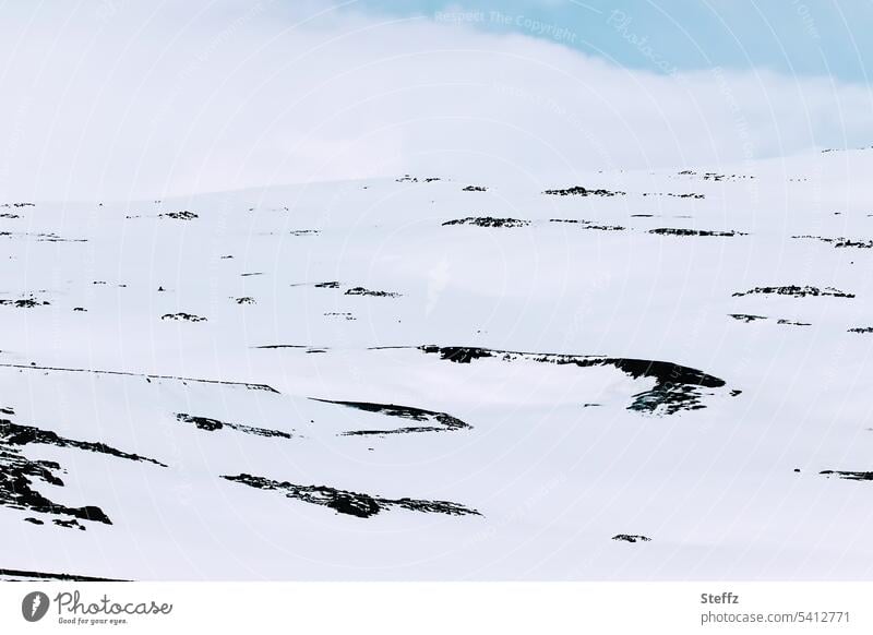 Schneelandschaft bei schönem Wetter auf Island Ostisland Himmel und Erde Schneedecke verschneit felsig schneebedeckt Islandwetter Himmelblau Felsen Hügel