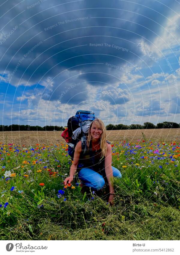 Frau auf einer Wanderung Farbfoto Wildblumenwiese Himmel Wolken Rucksackurlaub Wolkenhimmel Freude natur geniessen freizeit Abenteuer wandern Natur
